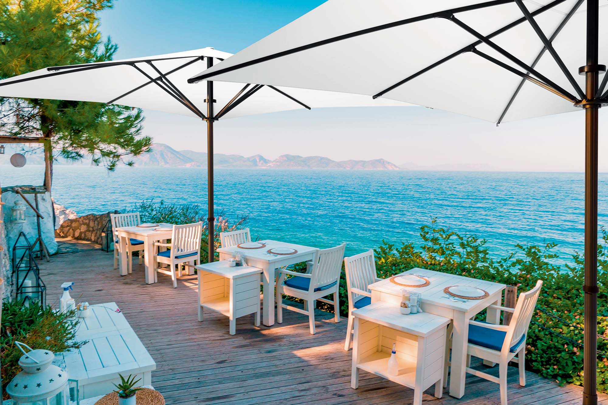 Baham Pure Sonnenschirm auf einer Terrasse eines Restaurants, mit Blick aufs Meer.